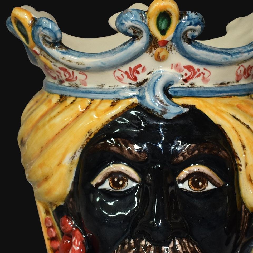 Ceramiche di Caltagirone fatti a mano, volto regale con corona blu e gialla, dettaglio artigianale