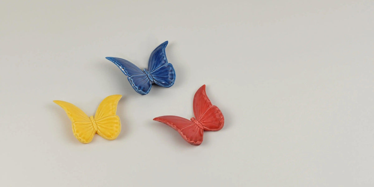 Bomboniere farfalle ceramiche Caltagirone fatti a mano giallo, blu e rosso su sfondo chiaro