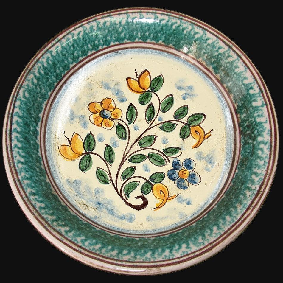 Ceramiche di Caltagirone fatti a mano con motivi floreali gialli e blu su fondo crema e bordo verde