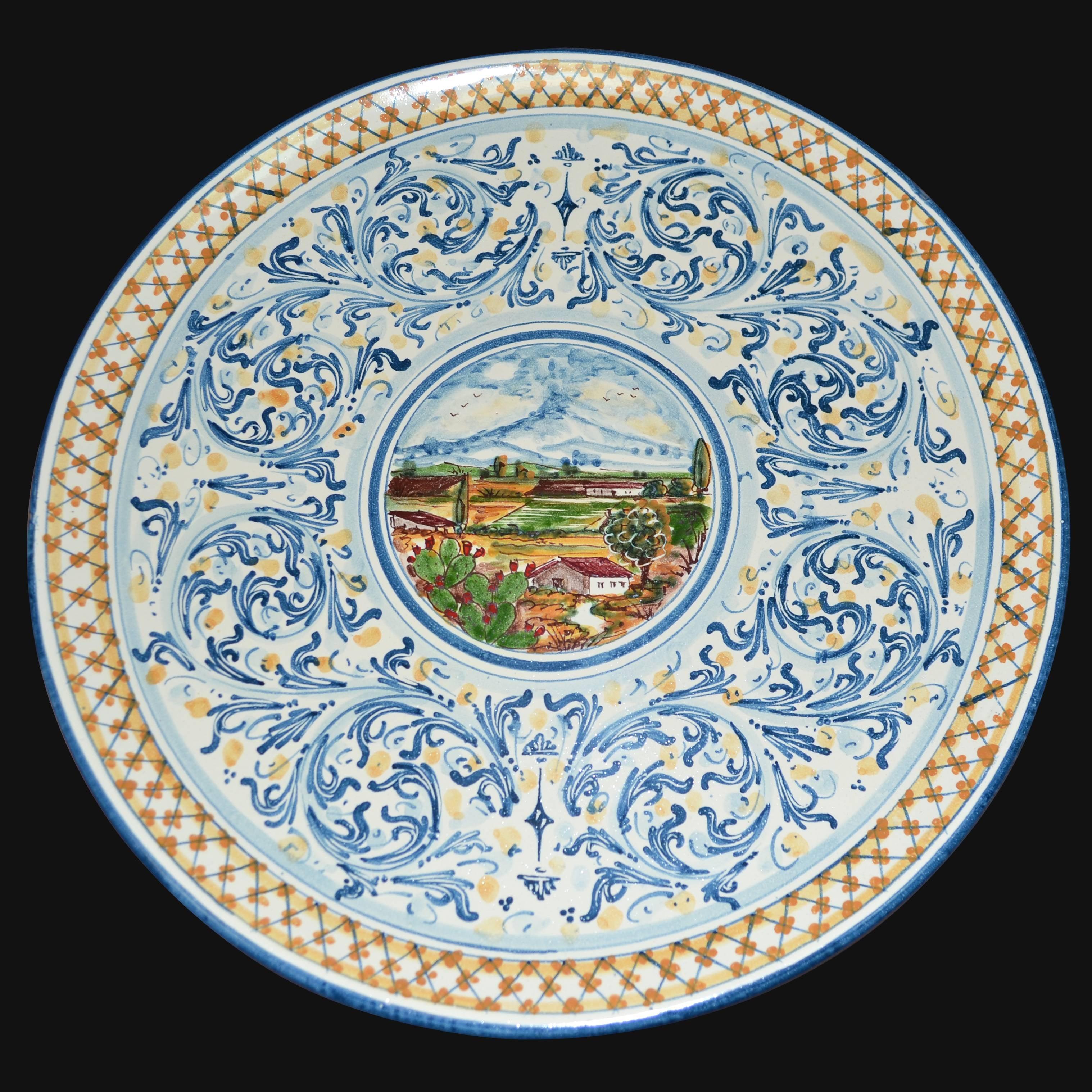 Piatto in ceramica di Caltagirone fatta a mano con paesaggio rurale e decori blu e arancio